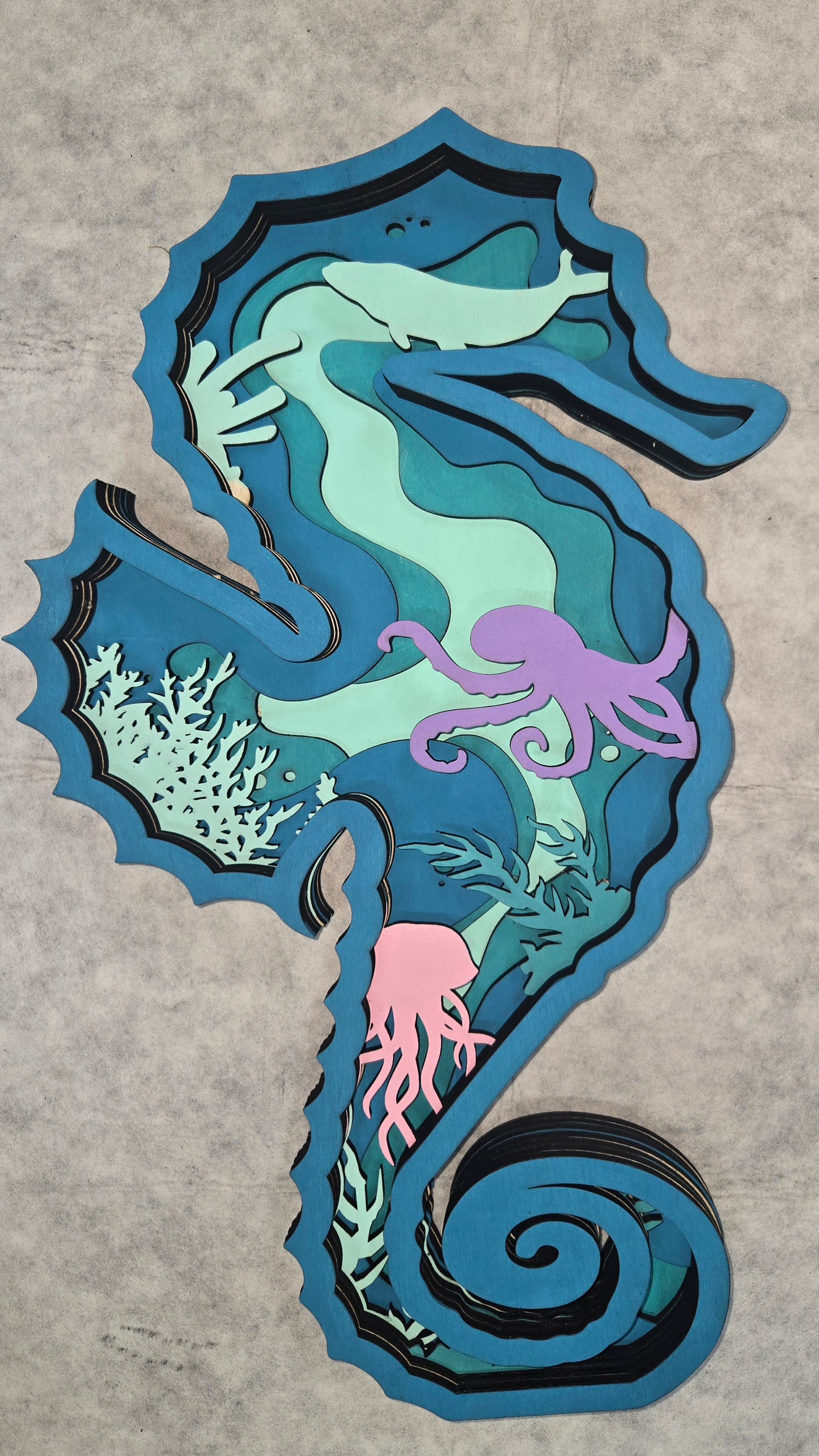 Multi-layered wall art that transcends traditional display limitations. This versatile multi-layered Seahorse Ocean functions seamlessly as a standalone accent for tables, countertops, and mantles, or mounts elegantly on walls for dramatic visual impact. Crafted with dimensional layering that creates depth and sophistication, it adapts to any interior design scheme. Whether you're seeking a focal point for a shelf, a statement piece above a fireplace, or a gallery wall installation, this art delivers profes